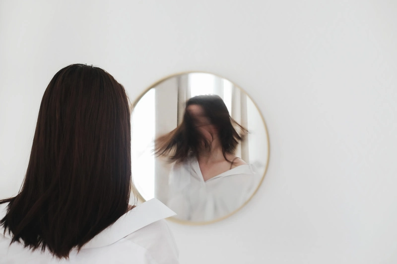 A woman with OCD looking in a mirror