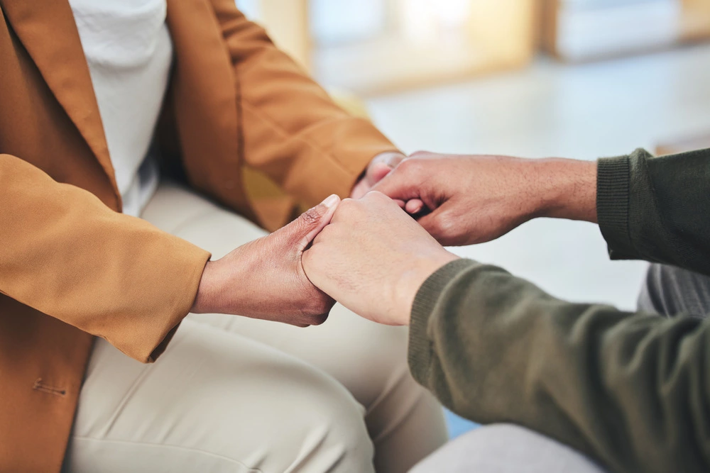 support mental health and patient holding hands with therapist in counseling session