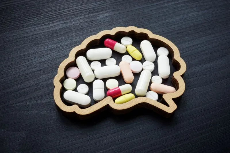 An artistic representation of mental health medications arranged within the shape of a brain, symbolizing the importance of the role that medical professionals play in prescribing mental health medications.