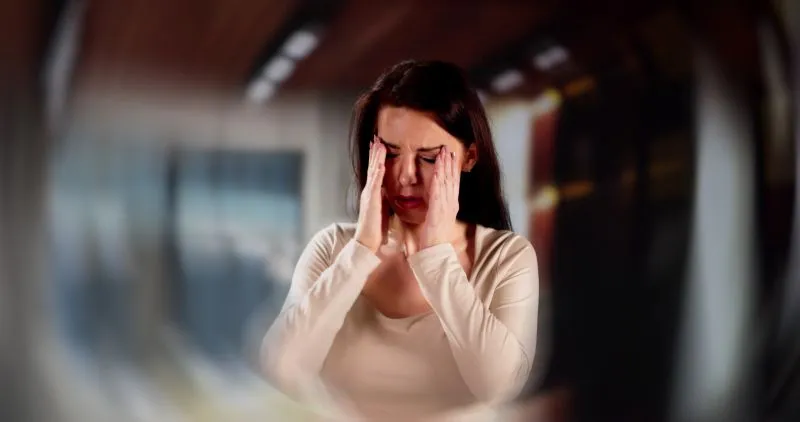 A woman visibly distressed, rubbing her temples and closing her eyes in an attempt to relieve tension. This moment emphasizes the physical and mental strain caused by stress related disorders