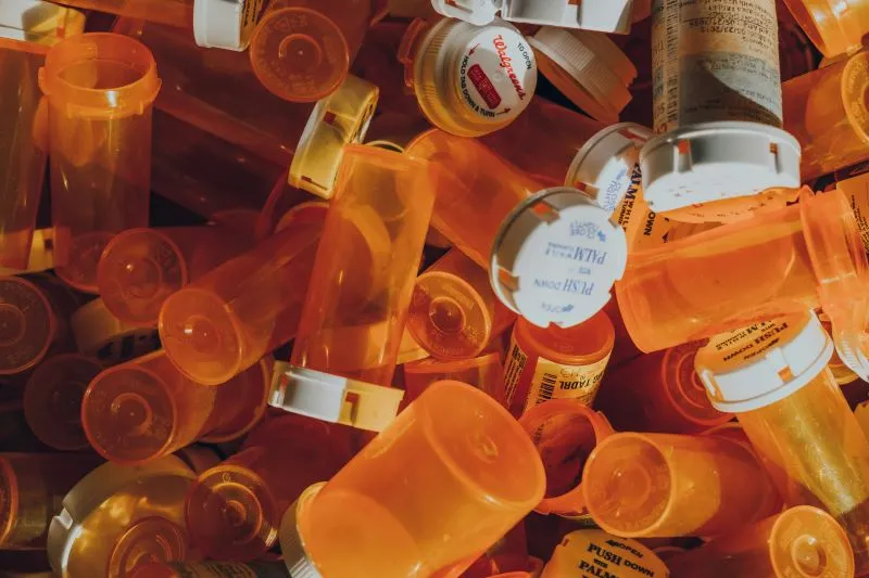 A pile of prescription bottles, including Adderall, symbolizing the collection of medications that might be used for various conditions, including questions about how long it takes for Adderall to work.
