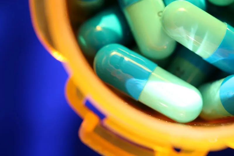 Close-up of a container filled with Adderall capsules, illustrating the question of how long it takes for Adderall to take effect.